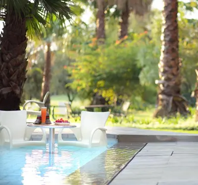 a table and chairs sitting next to a pool at The Lakes Boutique Lodge in Pretoria