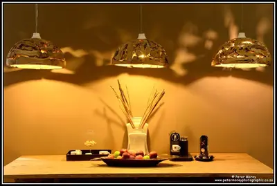a table with a bowl of fruit and three lights at The Lakes Boutique Lodge in Pretoria