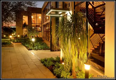 a building with lights and plants in front of it at The Lakes Boutique Lodge in Pretoria