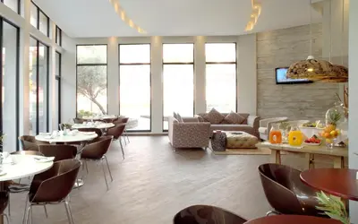 a restaurant with tables and chairs and a couch at The Lakes Boutique Lodge in Pretoria