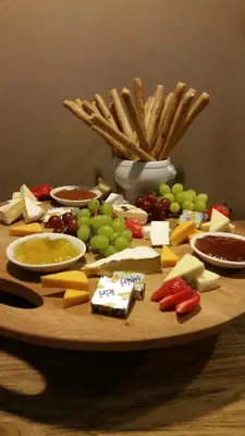a wooden table with cheese and other foods on it at The Lakes Boutique Lodge in Pretoria
