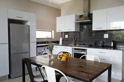 a kitchen with a wooden table with a bowl of fruit on it at The Lakes Boutique Lodge in Pretoria