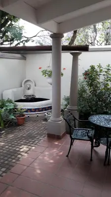 a patio with a table and chairs and a fountain at House Rossini in Pretoria