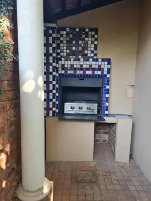 a kitchen with a fireplace with a tile wall at House Rossini in Pretoria