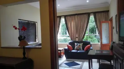 a living room with a couch and two windows at House Rossini in Pretoria
