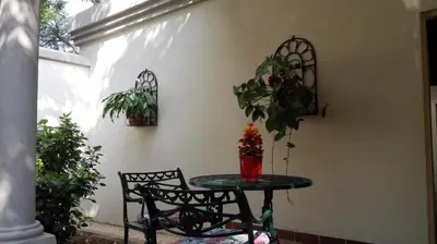 a table and chairs in a patio with plants at House Rossini in Pretoria