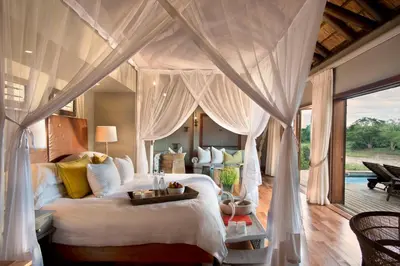 a bedroom with a bed with a canopy at Lion Sands Narina Lodge in Sabi Sand Game Reserve