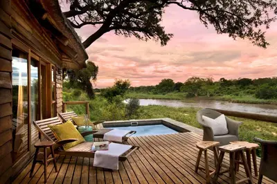 a deck with a plunge pool and chairs on a house at Lion Sands Narina Lodge in Sabi Sand Game Reserve