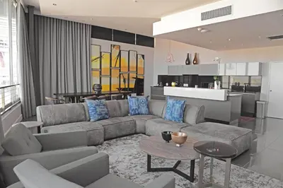 a living room with a couch and a kitchen at The Capital Menlyn Maine in Pretoria