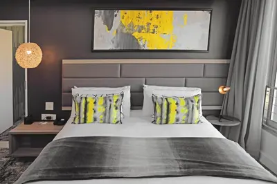 a bedroom with a large bed with two pillows at The Capital Menlyn Maine in Pretoria