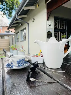 a table with a tea pot and a pair of spoons at Pari Guest House in Middelburg