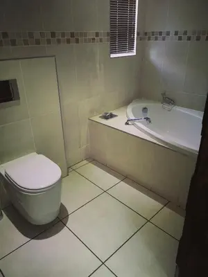 a bathroom with a toilet and a bath tub at AAA Rose Garden Guesthouse in Naboomspruit
