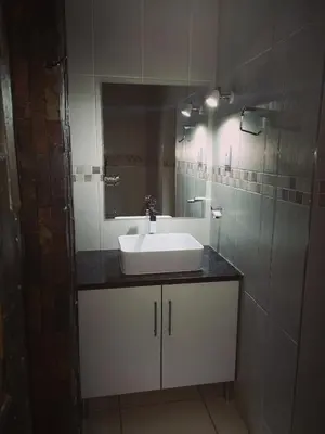 a bathroom with a sink and a mirror at AAA Rose Garden Guesthouse in Naboomspruit