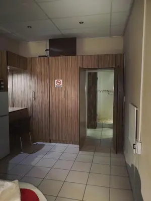 a room with a desk and a door to a room at AAA Rose Garden Guesthouse in Naboomspruit