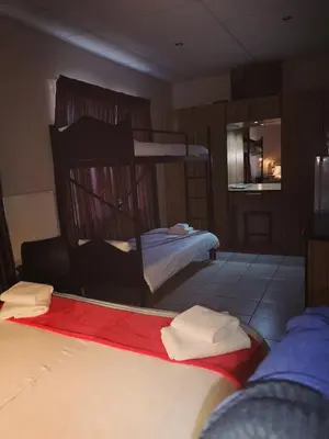 a bedroom with two bunk beds with towels on them at AAA Rose Garden Guesthouse in Naboomspruit