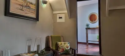 a hallway with a chair and a mirror on the wall at The Leopard Tree in Polokwane