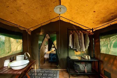 a bathroom in a tent with a sink in it at Nkula Walking Camp by RETURN Africa in Makuleke Contract Park