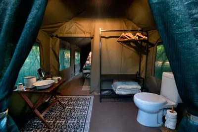 a bathroom with a toilet in a tent at Nkula Walking Camp by RETURN Africa in Makuleke Contract Park