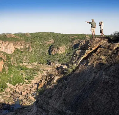two people standing on the edge of a cliff at Nkula Walking Camp by RETURN Africa in Makuleke Contract Park