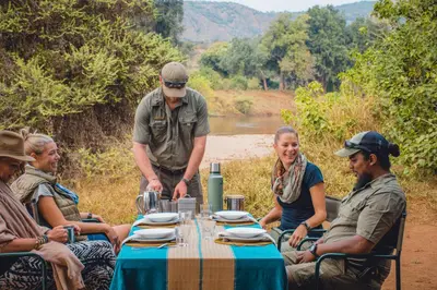 a group of people sitting around a table at Nkula Walking Camp by RETURN Africa in Makuleke Contract Park
