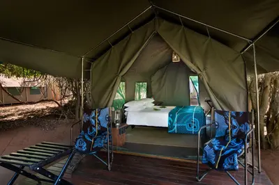 a tent with a bed and two chairs in it at Nkula Walking Camp by RETURN Africa in Makuleke Contract Park