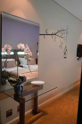 a mirror in a room with a bed and a table at Hudson House in Pretoria