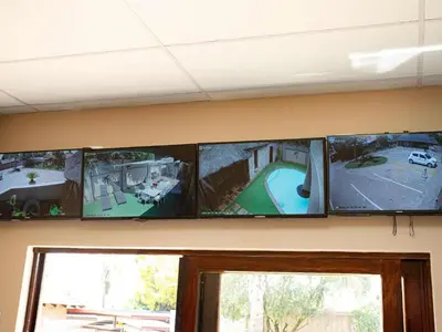 a row of five televisions on a wall at The Orion Guesthouse in Middelburg