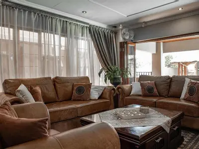 a living room with couches and a table at The Orion Guesthouse in Middelburg