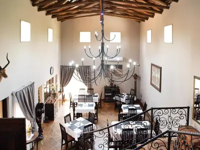 a restaurant with tables and chairs and a chandelier at The Orion Guesthouse in Middelburg