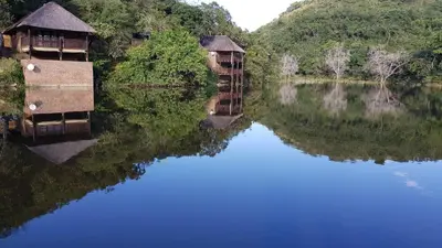 a reflection of two boats in a body of water at Sunset Creek Game Lodge in Karino