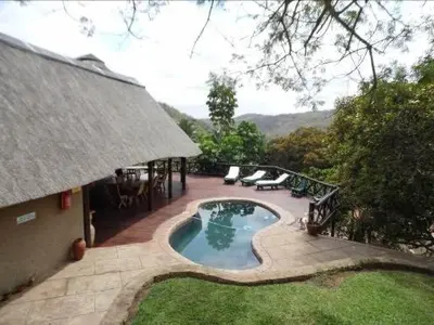 a backyard with a swimming pool and a house at Sunset Creek Game Lodge in Karino