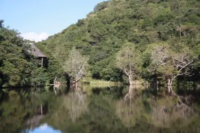 a reflection of a house in a body of water at Sunset Creek Game Lodge in Karino