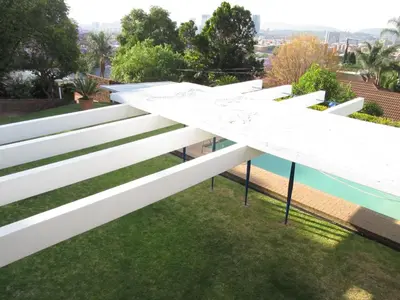 a white building on a roof with grass at House Sandrock Muckleneuk Selfcatering apartment in Pretoria