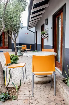 a table and chairs sitting outside of a building at Pro Active Guest House in Pretoria