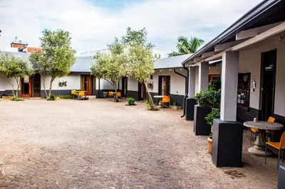 a courtyard of a building with tables and chairs at Pro Active Guest House in Pretoria