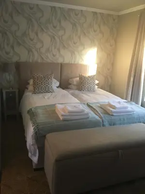 a hotel room with two beds with towels on them at Alibama House in Nelspruit
