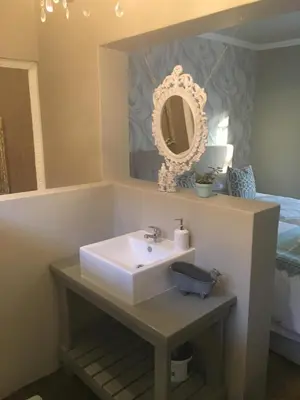 a bathroom with a sink and a mirror at Alibama House in Nelspruit