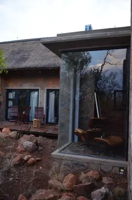 a mirror in front of a house with a chair at Kukama's Rest at Zebula 317 in Mabula