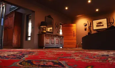 a living room with a couch and a mirror at Kukama's Rest at Zebula 317 in Mabula