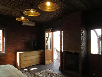 a living room with a fireplace and a wooden ceiling at Kukama's Rest at Zebula 317 in Mabula