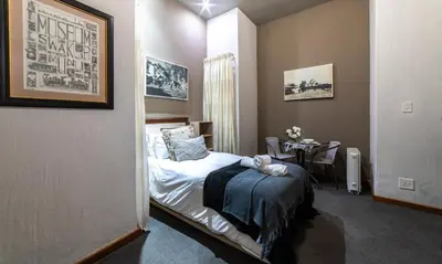 a bedroom with a bed and a table in it at Craigivar Guesthouse in Pretoria