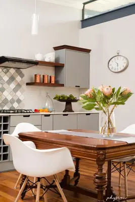 a kitchen with a wooden table and white chairs at Craigivar Guesthouse in Pretoria