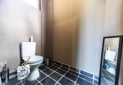 a bathroom with a toilet and a mirror at Craigivar Guesthouse in Pretoria
