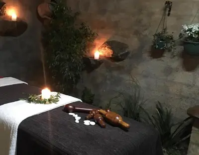 a table with two candles and a wooden animal on it at Guinea Feather Country Lodge & Spa in Groblersdal