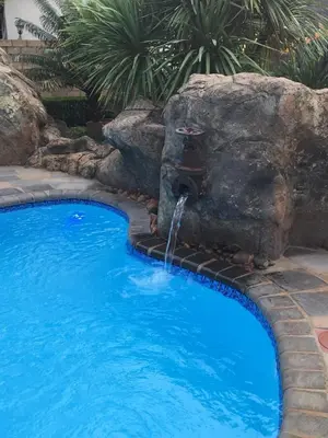 a swimming pool with a water fountain at Guinea Feather Country Lodge & Spa in Groblersdal