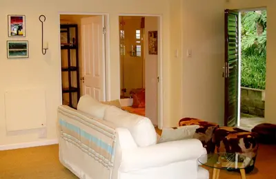 a living room with a white couch and a glass table at umSisi Cottage in White River