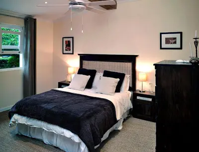 a bedroom with a bed with two night stands and two lamps at umSisi Cottage in White River