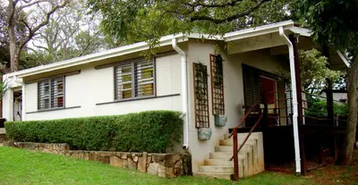 a white house with a staircase in front of it at umSisi Cottage in White River