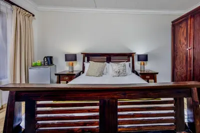 a bedroom with a large bed with two night stands at 42onKing in Centurion