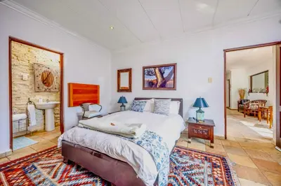 a bedroom with a large bed and a bathroom at 42onKing in Centurion